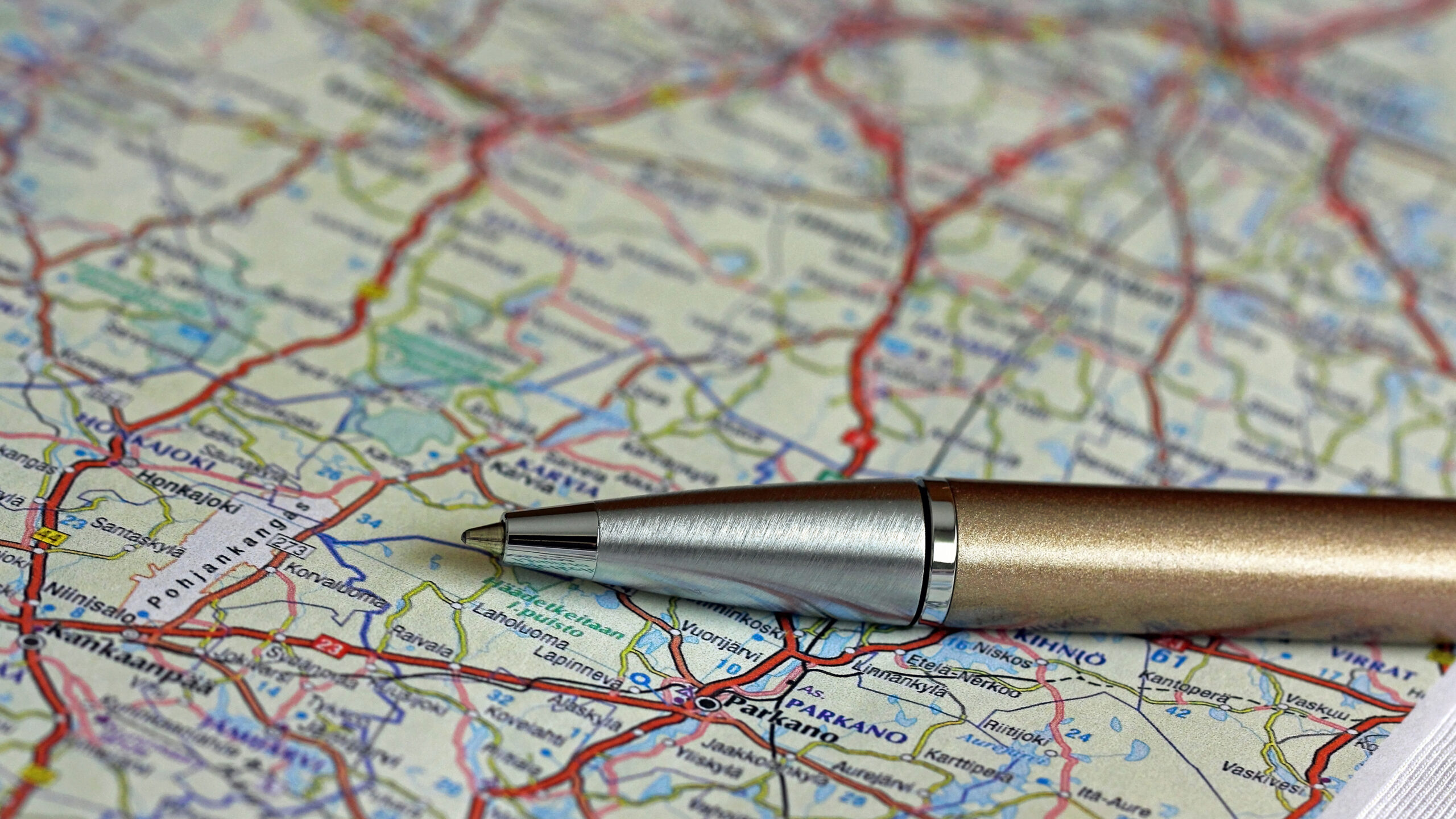 Pen lying on road map