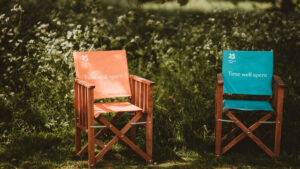 Deck chairs in woodland with words "Time well spent" printed on them