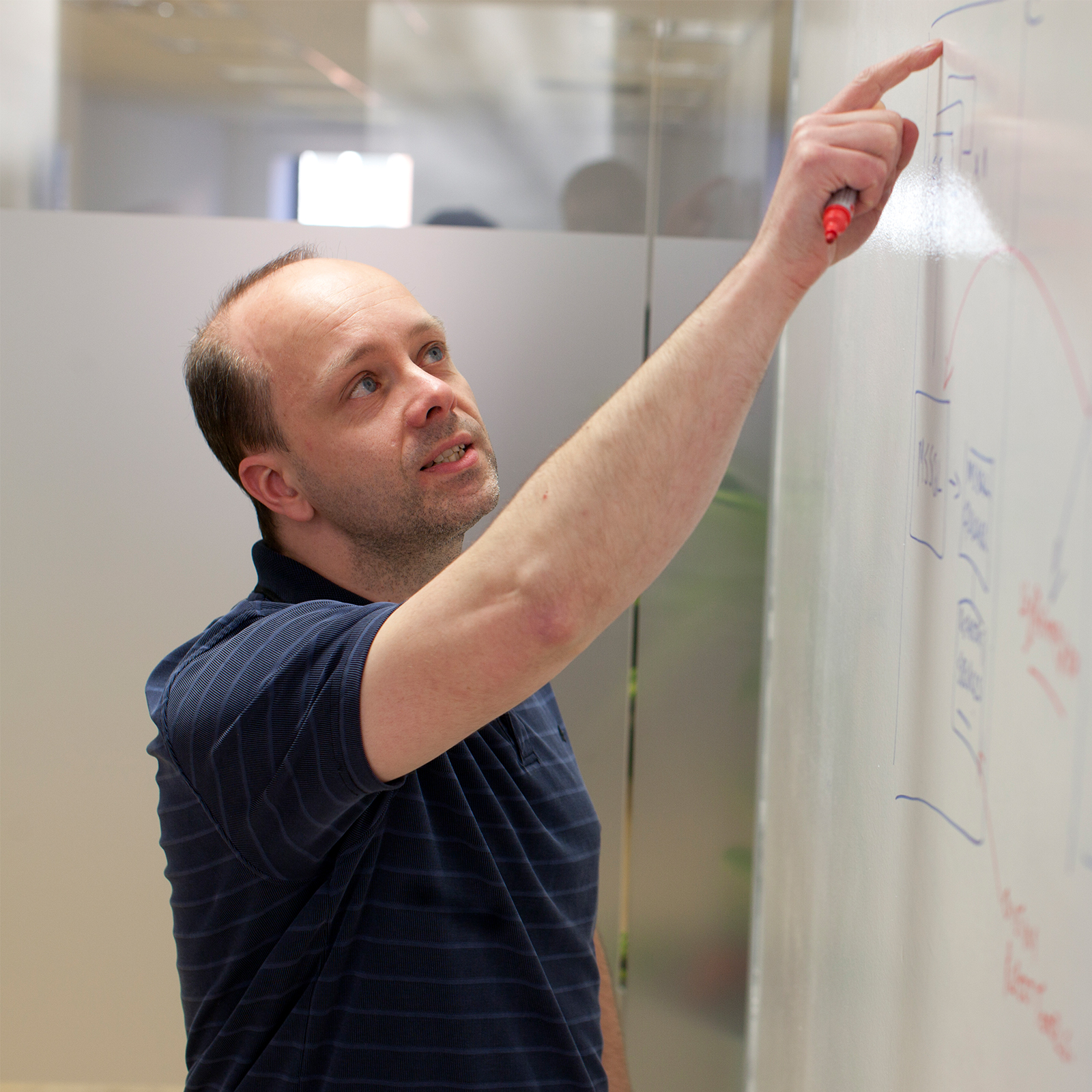 a man pointing to the data on a board