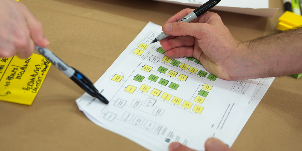 People adding notes to an information architecture diagram