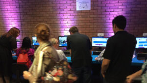 group of people looking gathered and looking on the computer monitors