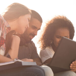 Three people looking at a laptop screen