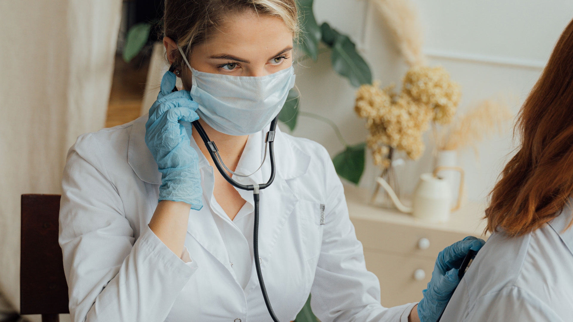 Doctor using stethoscope on patient