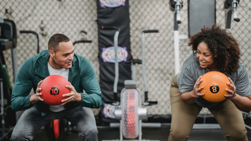 Two people exercising with medicine balls