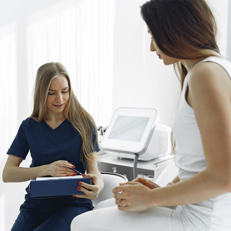 Doctor in consultation with patient sat on a bed