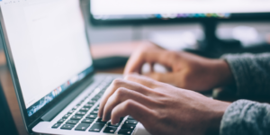 Close up of person's hands typing on laptop