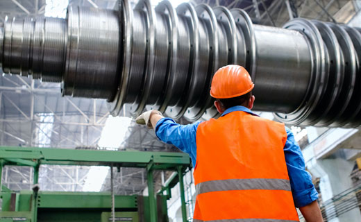 Person in hard hat and hi-vis jacket looking at machinery